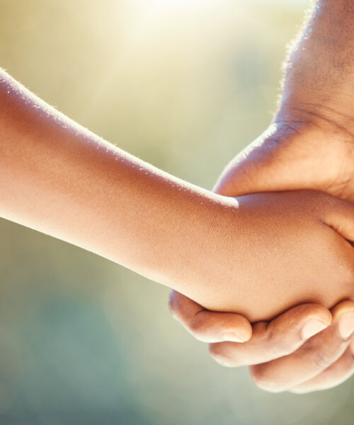 Trust, family and adoption with father and child holding hands while walking together outside. Parent and son showing security, care and love with man and boy sharing a safe and special bond